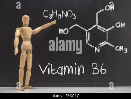 Doll articulated teaches in a blackboard the chemical composition of the vitamin B6, conceptual image Stock Photo