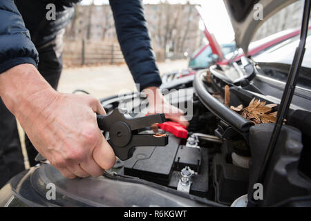 Person Using Jumper Cables To Charge Car's Dead Battery Stock Photo