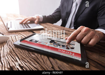 Businessman Reading News On Digital Tablet Stock Photo