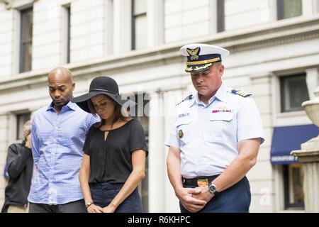 Cast members Brandon Victor Dixon (Aaron Burr) and Lexi Lawson (Eliza Hamilton) of the esteemed Broadway musical, Hamilton, bow their heads in a moment of silence with Capt. Scott Clendenin, commanding officer of the Coast Guard Cutter Hamilton to honor the shared namesake of the Cutter Hamilton and the play, founder of the Coast Guard, Alexander Hamilton, at his grave at Trinity Church in New York City, May 26, 2017. The wreath-laying ceremony was part of Fleet Week New York and Memorial Day weekend activities. U.S. Coast Guard Stock Photo