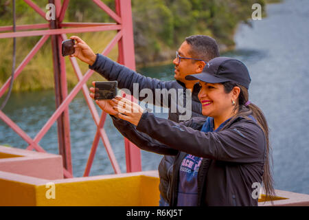 CUICOCHA, ECUADOR, NOVEMBER 06, 2018: Unidentified tourists taking selfies in front of the Cuicocha lake in the Province of Imbabura in Ecuador. Stock Photo