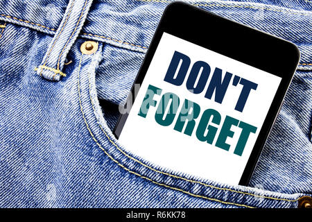 Conceptual hand writing text caption inspiration showing Do Not Forget. Business concept for Don t memory Remider Written phone mobile phone, cellphone placed in the man front jeans pocket. Stock Photo