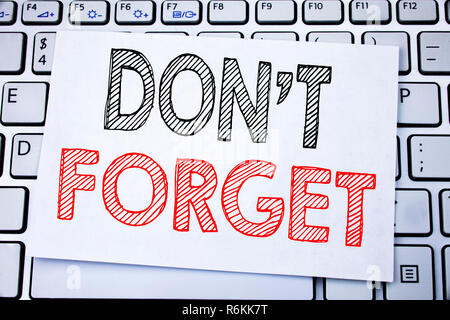 Handwritten text caption showing Do Not Forget. Business concept writing for Don t memory Remider written on sticky note paper on the white keyboard background. Stock Photo