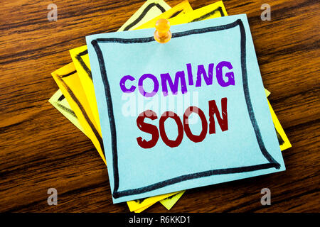 Writing text showing Coming Soon. Business concept for Under Construction written on sticky note paper on the wooden background. Stock Photo