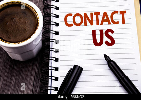 Writing text showing Contact Us. Business concept for Customer Support written on notebook book note paper on the wooden wood background. With coffee and black marker. Stock Photo