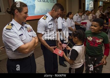 NEW YORK (May 27, 2017) Coast Guardsman assigned to USCGC Hamilton (WMSL 753) and Sailors assigned to the amphibious assault ship USS Kearsarge (LHD 3) receive gifts from Project Hope children at the Times Square Church in downtown Manhattan for 2017 Fleet Week New York (FWNY). FWNY, now in is 29th year, is the city’s time honored celebration of the sea services. It is an unparalleled opportunity for the citizens of New York and the surrounding tri-state area to meet Sailors, Marines and Coast Guardsmen, as well as witness firsthand the latest capabilities of today’s maritime services. Stock Photo