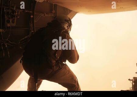 A crew chief with Marine Medium Tiltrotor Squadron (VMM) 363 prepares to call in Marines with 3rd Marine Regiment to board the aircraft while participating in a long range raid simulation during Integrated Training Exercise (ITX) 3-17 at Marine Corps Air Station Yuma, Arizona, May 28. ITX is a combined-arms exercise enabling Marines across 3rd Marine Aircraft Wing to operate as an aviation combat element integrated with ground and logistics combat elements as a Marine air-ground task force. More than 650 Marines and 27 aircraft with 3rd MAW are supporting ITX 3-17. Stock Photo