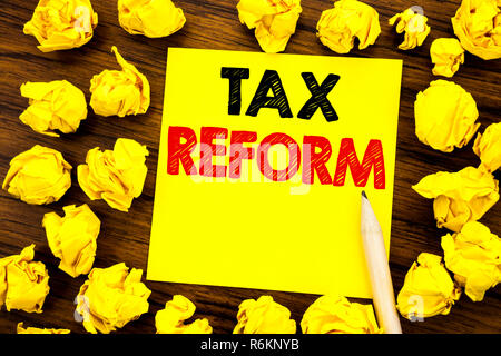 Writing text showing Tax Reform. Business concept for Government Change in Taxes Written on sticky note paper, wooden background with folded yellow paper meaning thinking Stock Photo