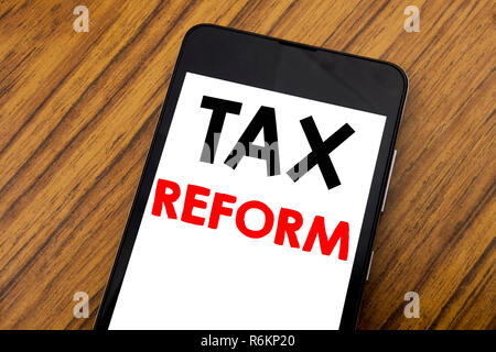 Word, writing handwriting Tax Reform. Business concept for Government Change in Taxes Written on mobile phone cellphone, wooden background with copy space. Stock Photo