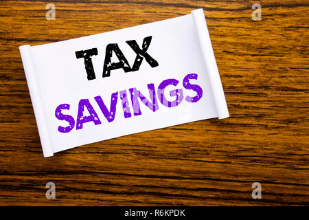 Word, writing Tex Savings . Business concept for Tax Savings Extra Money Refund written on sticky note paper on the wooden wood structure visible background. Stock Photo