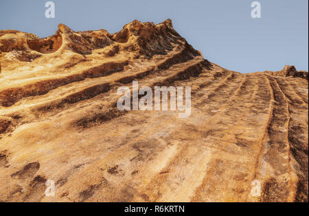 Interesting orange brown rock formation in the Blue Mountains Australia with a sand stone type texture and a ridged ripple or wave structure. Stock Photo