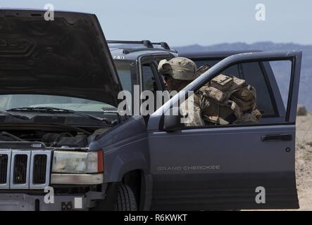 U.S. Marine Corps Pfc. Tanner A. Thatcher, a rifleman with Echo Company, 2nd Battalion, 6th Marine Regiment, 2d Marine Division (2d MARDIV), inspects a role-player’s vehicle at a checkpoint during counter-improvised explosive device (IED) training as part of Talon Exercise (TalonEx) 2-17, Marine Corps Air Ground Combat Center, Twentynine Palms, C.A., April 27, 2017. The purpose of TalonEx was for ground combat units to conduct integrated training in support of the Weapons and Tactics Instructor Course (WTI) 2-17 hosted by Marine Aviation Weapons and Tactics Squadron One (MAWTS-1). Stock Photo