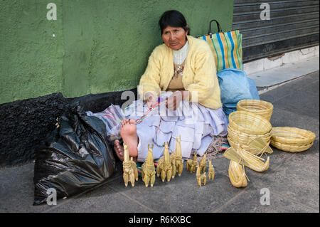 LA PAZ, BOLIVIA - AUGUST 19, 2017 : Unidentified street woman vendor wearing traditional clothing in the local Rodriguez market, selling souvenirs, in Stock Photo