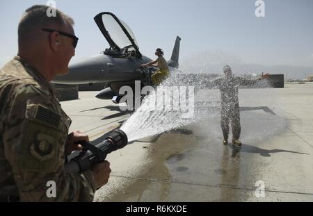 Chief Master Sgt. Peter Speen, command chief of the 455th Air Expeditionary Wing, hoses down Brig. Gen. Jim Sears at Bagram Airfield, Afghanistan, May 22, 2017. Sears, commander of the 455th AEW, conducted his fini flight out of Bagram Airfield. The fini flight is a time-honored military aviation tradition marking the last flight of a commander's tour. Stock Photo