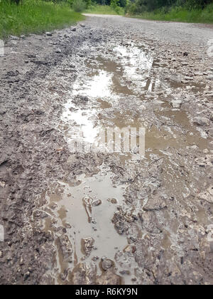 Water paddle on street after falling rain. Way after rain. Dirty puddle on road after rain. Dirt road with muddy puddles, autumn time. Abstract. Stock Photo