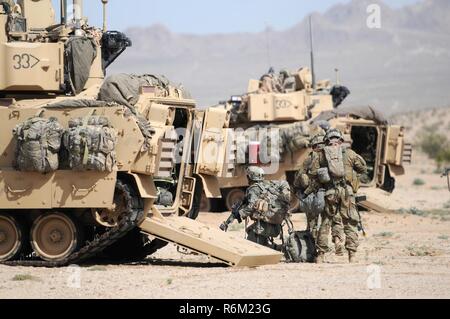 Soldiers of the 155th Armored Brigade Combat Team dismount from a Bradley Fighting Vehicle to move to their objective during a combined arms exercise at the National Training Center, Fort Irwin, California on May 30, 2017. (Mississippi National Guard Stock Photo