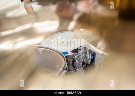 Drummer playing on drum set top view. Live music concert, band during performance. View and look through allong cymballs on snare drum and drum sticks Stock Photo