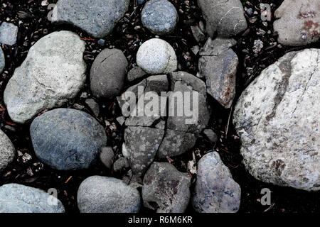 Round river rocks and a cracked stone background Stock Photo