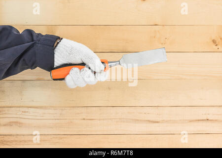 Hand in glove holding chisel Stock Photo