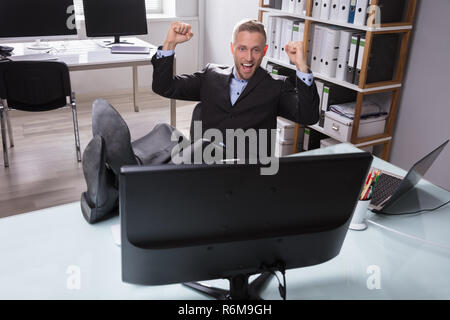 Excited Businessman Looking At Computer Stock Photo