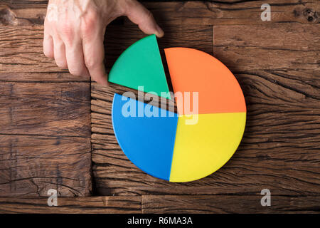Businessperson Placing A Last Piece Into Pie Chart Stock Photo