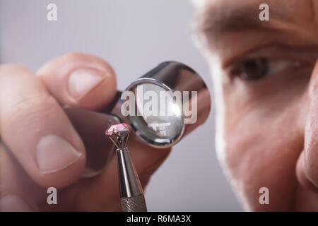 Person Checking Diamond Through Magnifying Loupe Stock Photo
