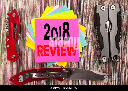 Writing text showing 2018 Review. Business concept for Feedback On Progress Written on sticky note wooden background with pocket knife Stock Photo