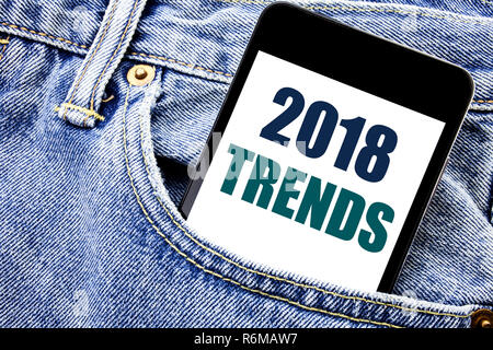 Conceptual hand writing text caption inspiration showing 2018 Trends. Business concept for Trending Data Prediction Written phone mobile phone, cellphone placed in the man front jeans pocket. Stock Photo