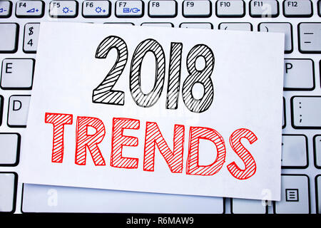 Handwritten text caption showing 2018 Trends. Business concept writing for Trending Data Prediction written on sticky note paper on the white keyboard background. Stock Photo
