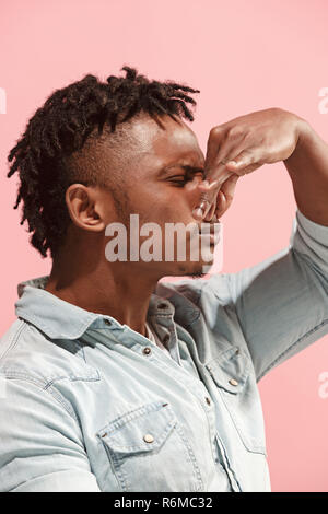 Let me think. Doubtful pensive Afro-American man with thoughtful expression making choice against pink background Stock Photo