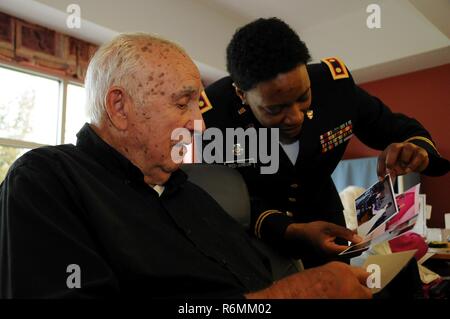 Maj. Angela Reed-Johnson, strategic operations chief for the Directorate of Human Resources for the U.S. Army Reserve’s 99th Regional Support Command at Joint Base McGuire-Dix-Lakehurst, New Jersey, visits May 26 with Dominic Ieropoli at the Veterans Memorial Home in Vineland, New Jersey.  Ieropoli is showing off photos from the 99th RSC’s dining out on May 12, an event to which dozens of residents from the home were invited. Stock Photo