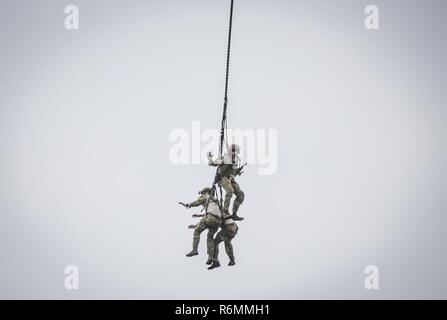 New Jersey Air National Guard TACP airmen from the 227th Air Support Operations Squadron hang from a Special Purpose Insertion Extraction system on a 1-150th Assault Helicopter Battalion UH-60 Black hawk helicopter during a demonstration at the Millville Wheels & Wings Air Show, in Millville, N.J., May 27, 2017. Stock Photo