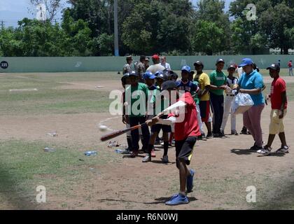 A local child works on his hitting technique during a baseball clinic the 346th Air Expeditionary Group hosted for area children May 20, 2017, in San Juan de la Maguana, Dominican Republic, as part of NEW HORIZONS 2017. The baseball clinic, organized by the task force in partnership with various non-governmental and other organizations, offered U.S. service members the opportunity to assist former major league baseball players and trainers in putting on a memorable event for 450 children, parents and other participants. Stock Photo