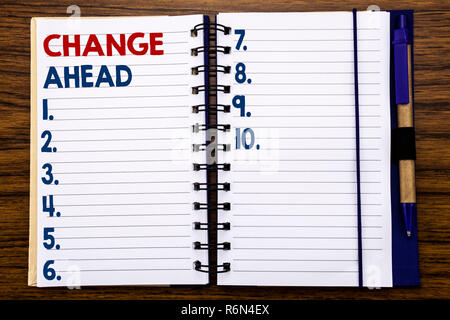 Writing text showing Change Ahead Red Word. Business concept for Future Changes Written on notebook note paper, wooden background with pen and marker. Stock Photo