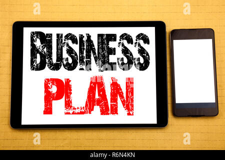 Hand writing text caption inspiration showing Business Plan. Business concept for Mission or Vision Written on tablet laptop, wooden background with sticky note, coffee and pen Stock Photo