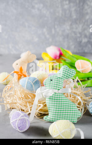 Easter composition with bunnies, eggs and tulips. Stock Photo