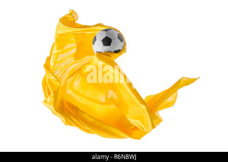 Soccer ball and Smooth elegant transparent yellow cloth isolated or separated on white studio background. Stock Photo
