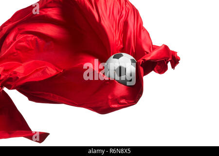 Soccer ball and Smooth elegant transparent red cloth isolated or separated on white studio background. Stock Photo