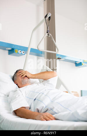 Patient in hospital room - suffering from pain after surgery Stock Photo