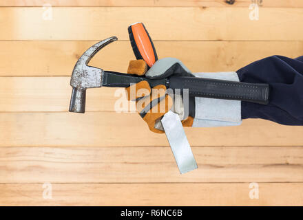 Hand in glove holding chisel and hammer Stock Photo