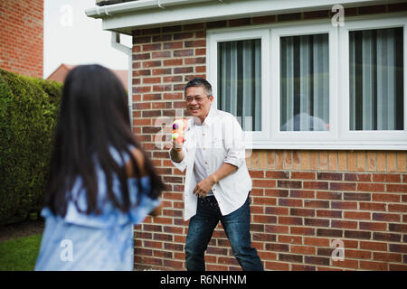 Having a Water Fight with Dad Stock Photo