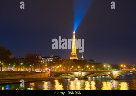 PARIS, FRANCE - NOVEMBER 10, 2018: Siene river embankment and Eiffel Tower with spotlight at night in Paris. Stock Photo