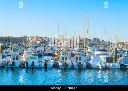 White yachts and motor boats moored by pier in marina, Peniche, Portugal Stock Photo
