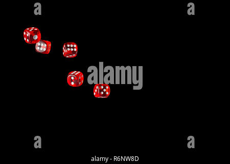 Gambling game. Rolling red dice isolated over black background with copy space. Stock Photo