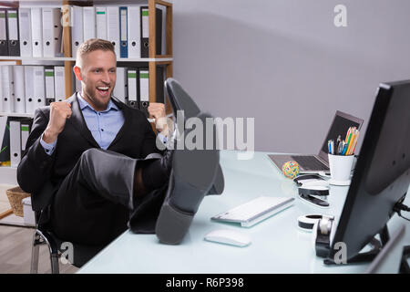 Excited Businessman Looking At Computer Stock Photo