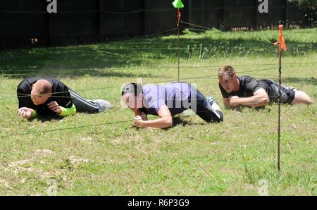 81st Medical Operations Squadron Team 2 members participate in the low crawl portion during the 81st Security Forces Squadron obstacle course competition May 16, 2017, on Keesler Air Force Base, Miss. The competition was held during National Police Week, which recognizes the service of law enforcement men and women. Stock Photo