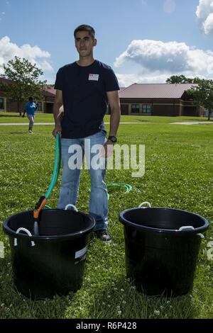 U.S. Marine Corps Private First Class Bryan Llanes, administrative specialist, Installation Personnel Administration Center, Headquarters and Support Battalion, Marine Corps Installations East, Marine Corps Base Camp Lejeune, fills a bucket with water during a Richlands Primary School field day, Richlands, N.C., May 25, 2017. Service members volunteered at the primary school and showed support to the youth in the Onslow County community through positive interaction. Stock Photo