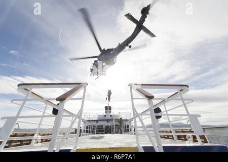 Coast Guard crewmembers from Maritime Safety and Security Team 91109, based in San Diego, are hoisted aboard a California Air National Guard 129th Rescue Wing HH-60G Pave Hawk helicopter during an interagency training exercise on the San Francisco Bay, April 25, 2017. Coast Guardsmen and women shield our nation by standing the watch alongside the Air National Guard and fellow servicemembers from all military branches. U.S. Coast Guard Stock Photo