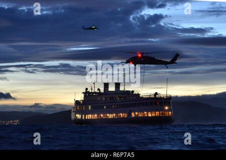 Crewmembers from Coast Guard Maritime Safety and Security Team 91109, based in San Diego, aboard a California Air National Guard 129th Rescue Wing HH-60G Pave Hawk helicopter prepare to fast-rope during an interagency training exercise after sunset on the San Francisco Bay, April 25, 2017. Servicememebrs from both branches train to respond to situations day or night. U.S. Coast Guard Stock Photo