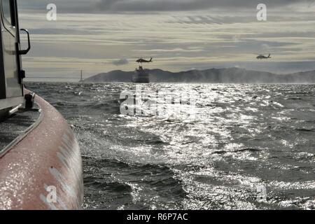 Coast Guard Maritime Safety and Security Team 91109 crewmembers aboard two California Air National Guard 129th Rescue Wing HH-60G Pave Hawk helicopters prepare to conduct a fast-rope training exercise on the San Francisco Bay, April 25, 2017. MSSTs consist of specially trained teams trained to interdict and neutralize potential threats and perform a broad range of port security and harbor defense missions, both domestic and foreign. U.S. Coast Guard Stock Photo